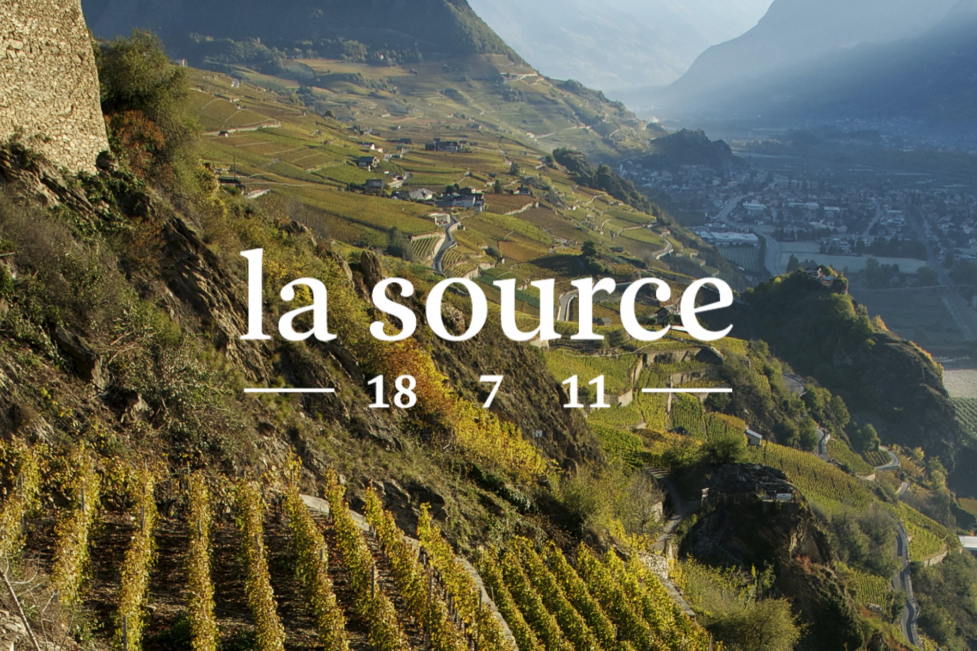 La Source Logo vor Weinanbaulandschaft