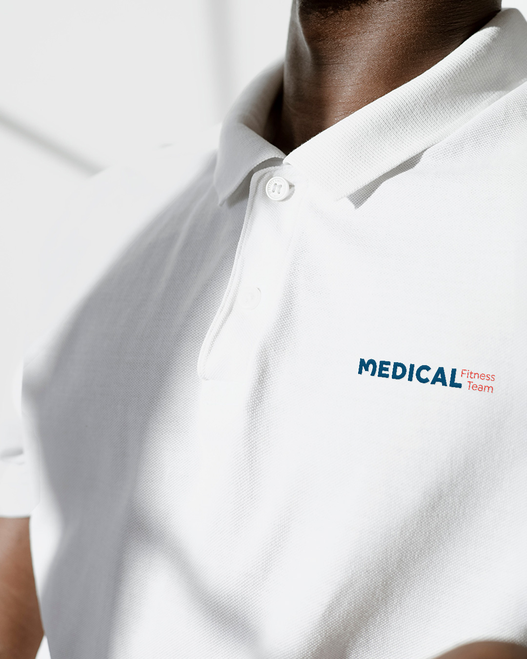 Logo Medical Fitness Team auf weissem Poloshirt